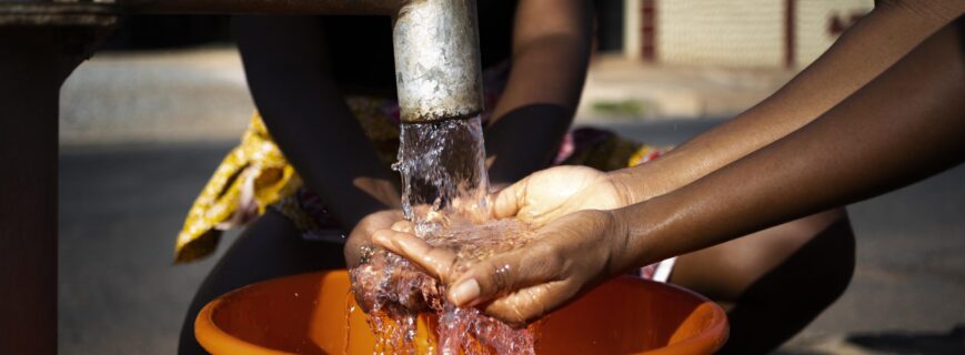 african-woman-pouring-water-recipient-outdoors